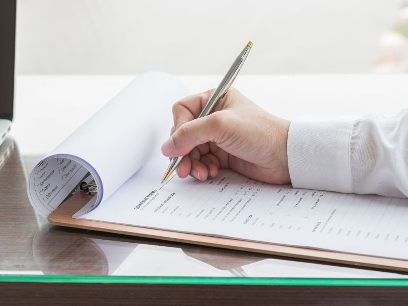 applicant-filling-in-company-application-form-document-applying-for-job-or-registering-claim-for-health-insurance
