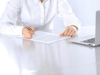 close-up-of-female-hands-with-pen-over-document-business-concept-lawyer-or-business-woman-at-work-in-office