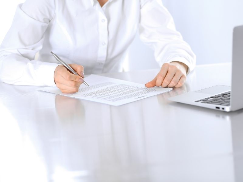 close-up-of-female-hands-with-pen-over-document-business-concept-lawyer-or-business-woman-at-work-in-office