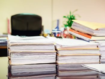 close-up-pile-of-unfinished-business-documents-on-office-desk-stack-of-business-paper